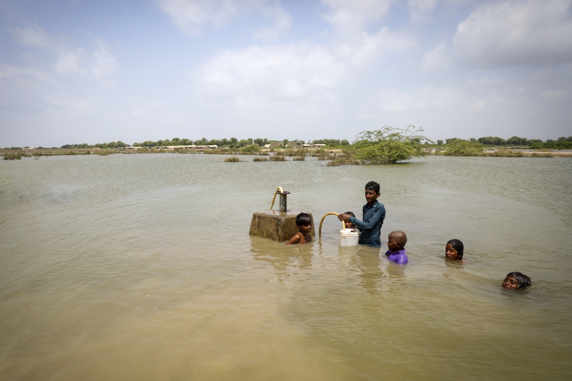 Young boys collecting drinking water from the main drinking water supply line under the flood water in Umerkot district, Sindh Province, Pakistan. Credit: UNICEF/UN0701706/Zaidi
